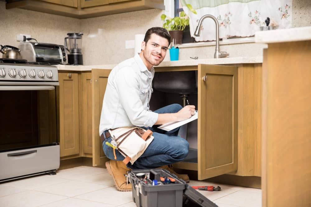 portrait attractive hispanic handyman writing work estimate before fixing kitchen sink 1 min