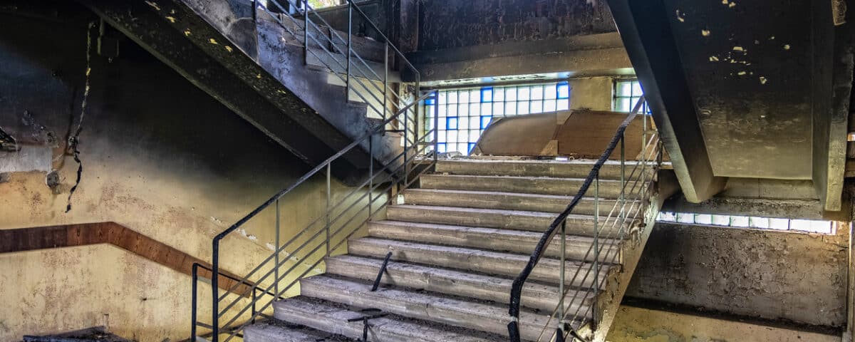 Burned interiors after fire in industrial or office building. Walls and staircase in black soot