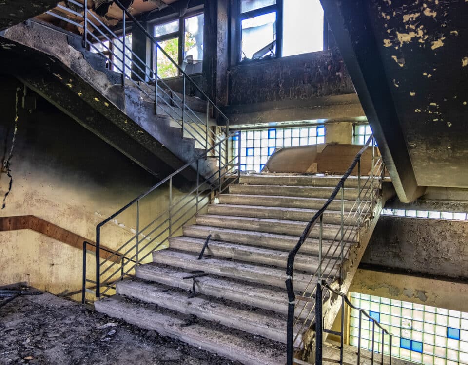 Burned interiors after fire in industrial or office building. Walls and staircase in black soot